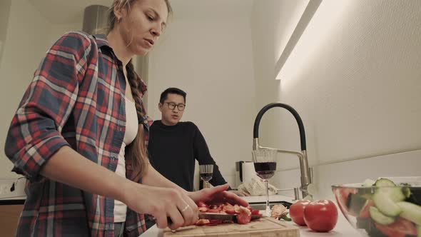 Couple cooking and drinks wine