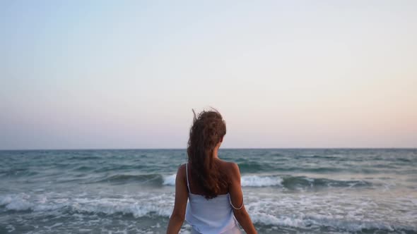 Woman Having Fun at Beach Jumping Around and Splashing Water alt
