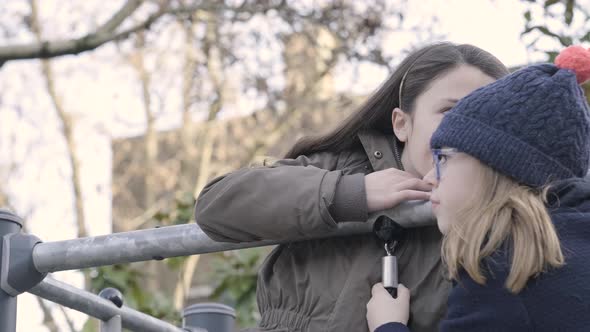 Children playing telephone game on the schoolyard during break time alt