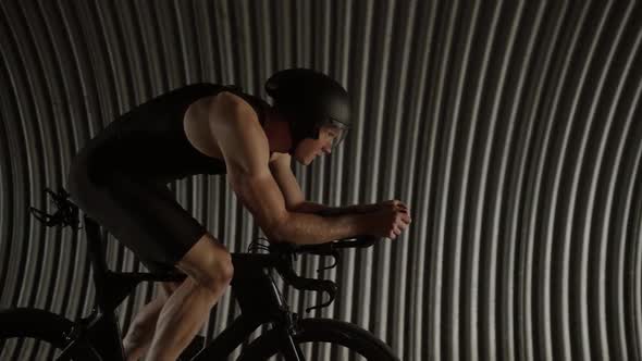 Professional Triathlete Rides a Cutting Bike Pro Cyclist Rides in a Tunnel Athlete Training for Race alt