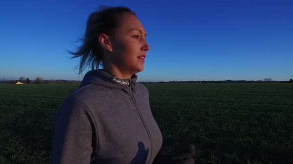 Slow Motion: Female Runner Across Countryside Fields On Sunny Morning alt