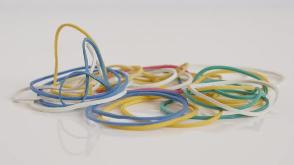 Various rubber bands on white background 4K tilting  footage