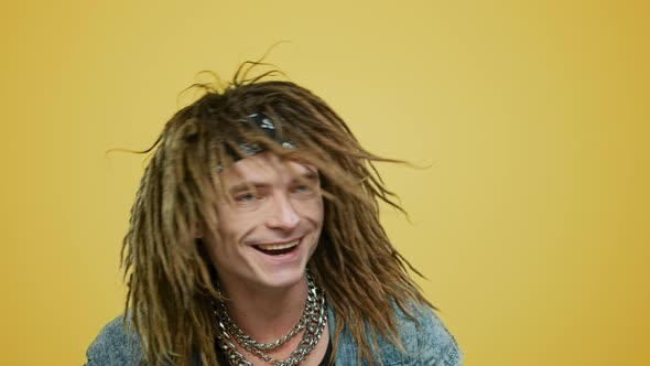 Joyful Rocker Dancing on Yellow Background. Smiling Man Waving Head alt