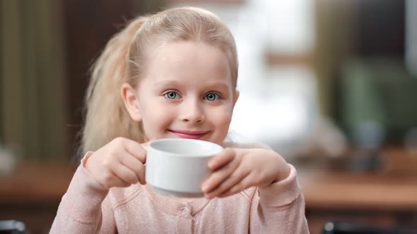 Face of Cute Baby Girl Holding Cup of Tea Posing at Cafe Have Fun alt