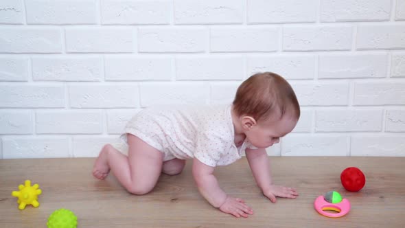 Cheerful baby girl playing with toys on floor