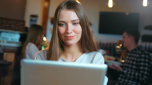 Young Happy Woman Using Tablet Computer in a Cafe alt