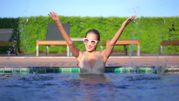 Young asian woman enjoy around outdoor swimming pool for leisure alt