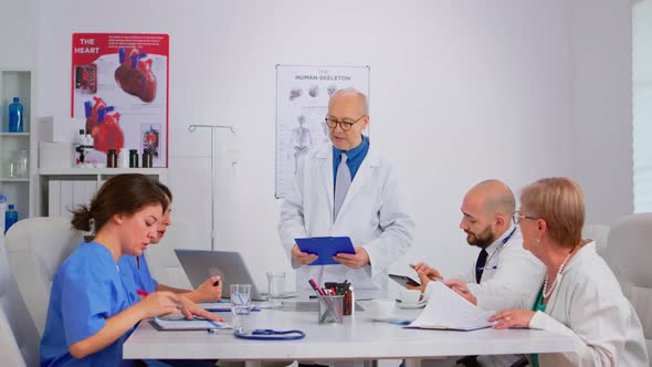 Senior Specialist Doctor Presenting Research Informations to Colleagues alt