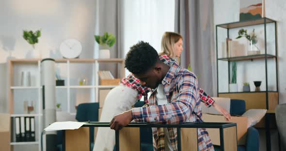 African American Guy Measuring Sizes of Rack with Tape Measure alt