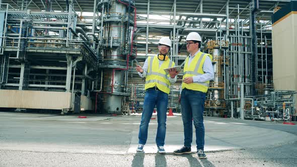 Oil Refinery Engineers are Discussing Plans at the Premises alt