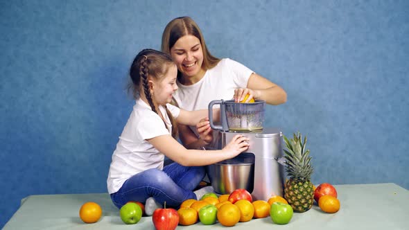 Happy Mother and Daughter Squeezing Fruits for Juice alt