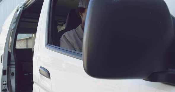 Young female van driver with a warehouse delivery alt
