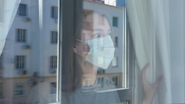 Woman Looking out The Window and Take Off Surgical Mask from Face.