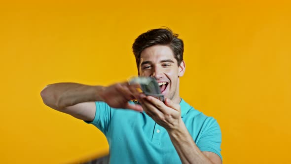 Man with Surprised Happy Face Scatters, Waste Money. Person Overspend US Currency. Guy in Blue Is alt