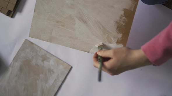 Woman Artist Applying White Paint on Painting Canvas in Design Studio alt