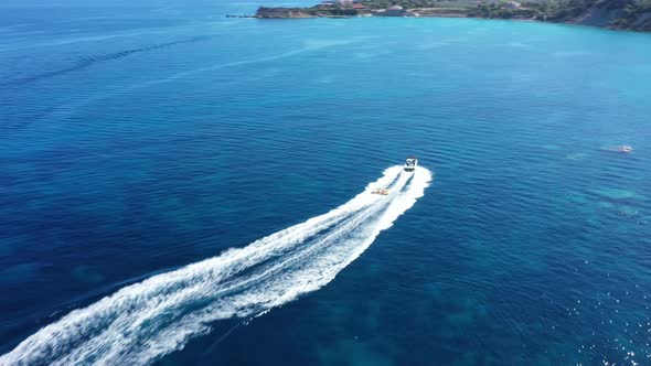 Aerial View of a Motor Boat Towing a Tube. Zakynthos, Greece