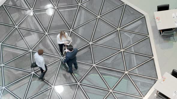 Two colleagues greeting businessman by shaking hands in office center