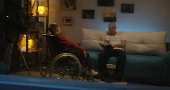 Grandpa Reading To Disabled Boy alt