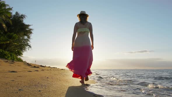 Back View Young Lady in Dress Waiving on Ocean Breeze Walking By Ocean Beach alt