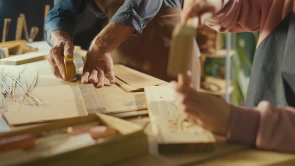 Closeup of Male Hands of Carpenter and Apprentice Doing Woodcarving alt