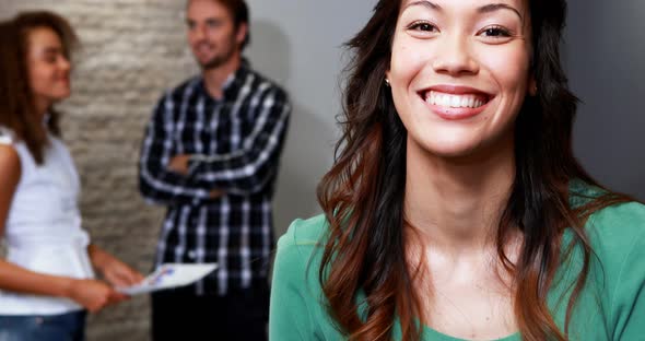 Portrait of female executive standing in office alt
