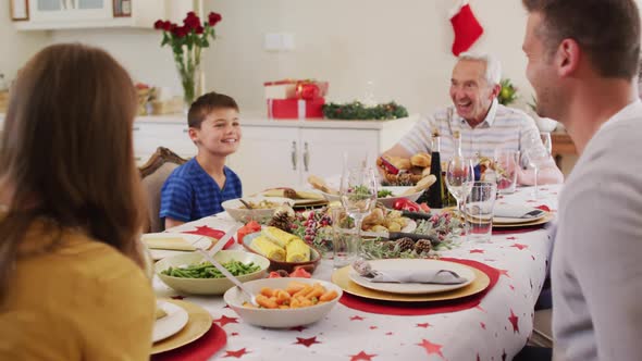 Caucasian family sitting on dining table enjoying lunch together during christmas at home alt