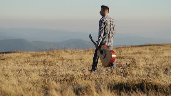 Man With Acoustic Instrument Enjoying Nature and Sunlight