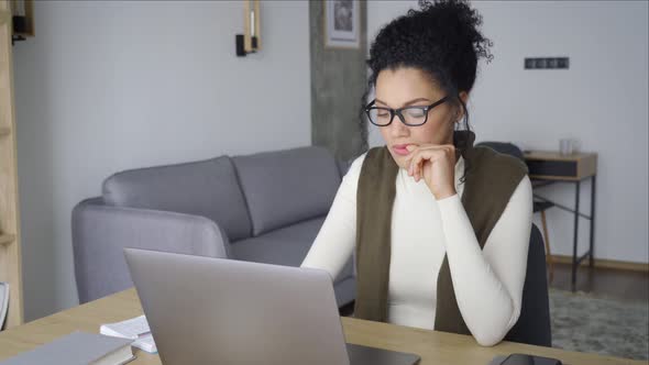 Young African American Mixed Race Girl Sitting at Desk Typing on Pc Indoors alt