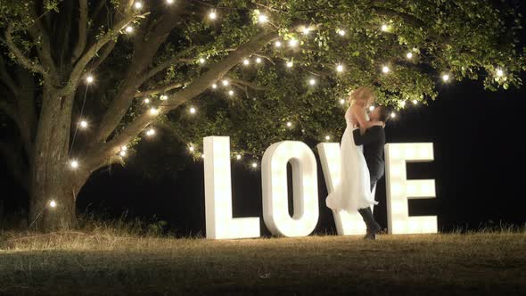 Groom lifting up his bride alt