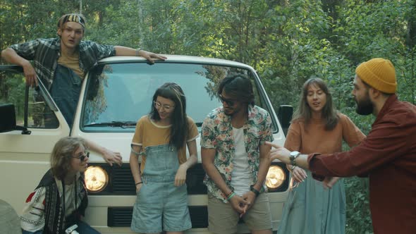 Joyous Friends Posing by Van for Group Photo alt