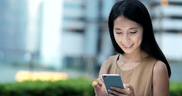 Business woman using smart phone in the city at night  alt
