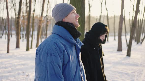 Beautiful Loving Couple Walking and Hugging in Winter Forest alt