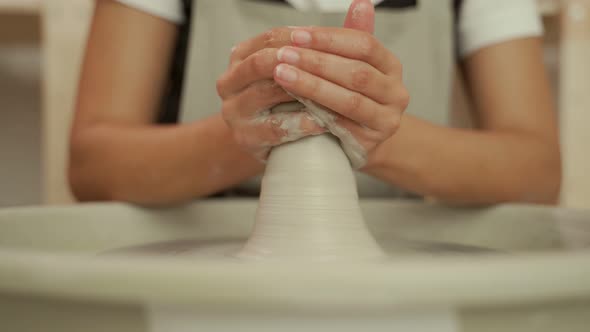Artisan Shaping Clay Vessel on Pottery Wheel