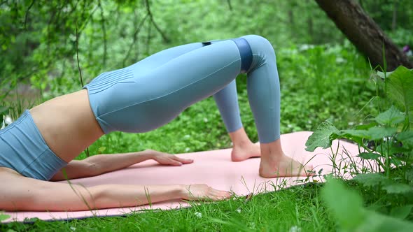 Beautiful Fit Woman in Sportswear Doing Exercises on Pink Yoga Mat with Fitness Gum