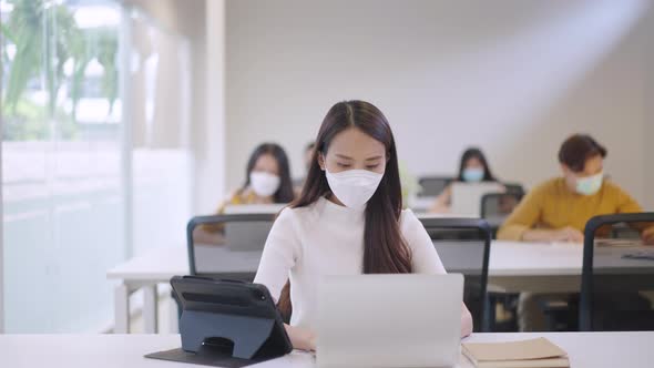 Asian creative business team working after lockdown with protective prevention face mask.