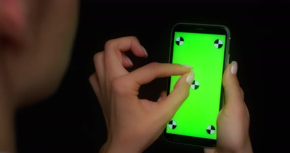 Woman Using Mobile App on Green Screen Phone Makes a Twofinger Zoom Gesture