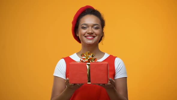Cheerful Woman Stretching Hands Showing Into Camera Red Giftbox, Holiday Present alt