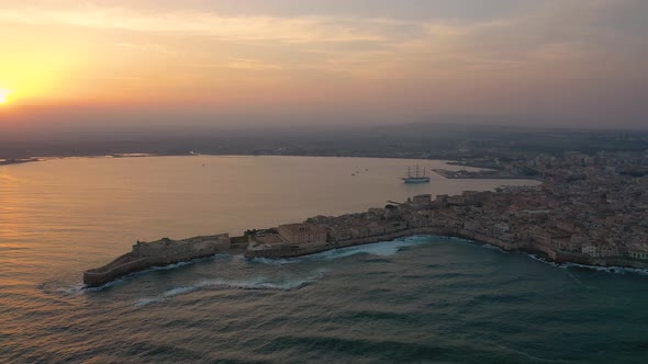 A Bird's Eye View of Ortigia Island at Sunset. Sailing Ship Out of the Bay. Sicily