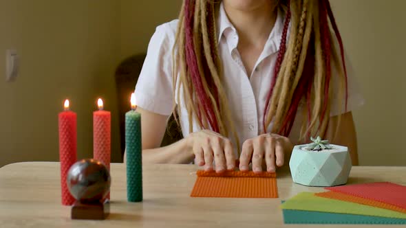 Young Modern Girl with Dreadlocks in White Shirt Is Performing a Workshop of Making Beeswax Candles alt