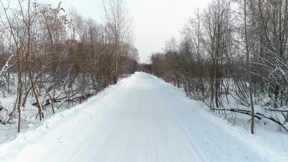 Winter Road in the Snow, Aerial Footage. Camera Move Ahead.