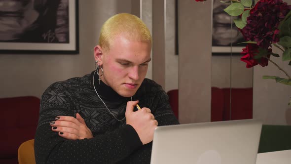 Tired Sad Homosexual Man Looking at Laptop at the Home Office alt