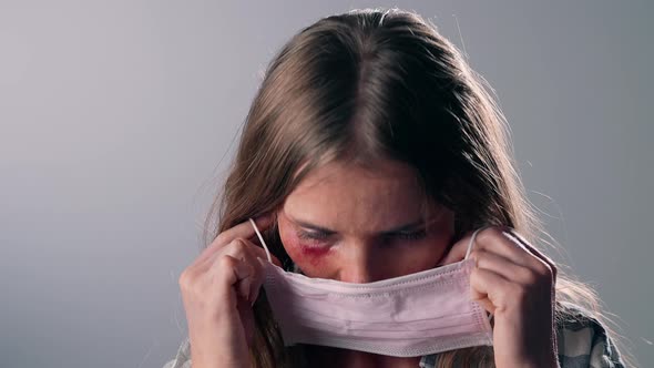 Woman Victim of Domestic Violence Puts a Medical Mask on His Face