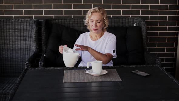 Adult Woman Drinking Tea and Talking on the Phone