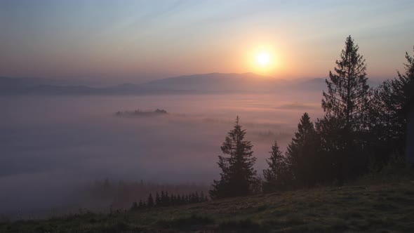 Time lapse of Sunrise over fog in Carpathian mountains with lens flare