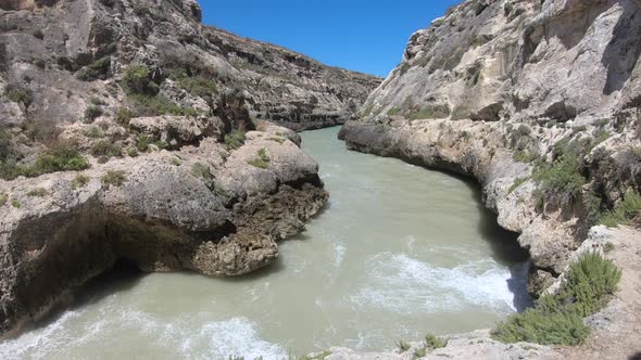 waves crashing against a rocky cove in Malta alt