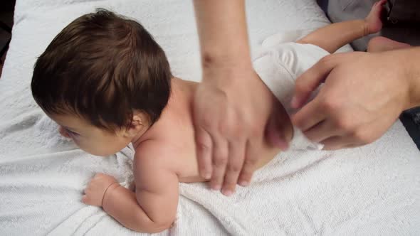 The Masseur Gives a Massage To the Baby. A Child Who Is Being Massaged Is Lying on the Couch. Baby