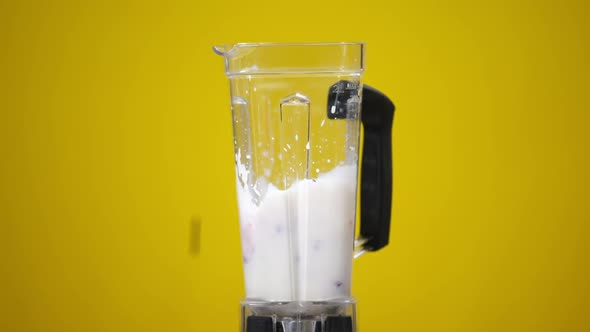 Bunch of Berries Falling in White Milk in Blender in Slow Motion alt