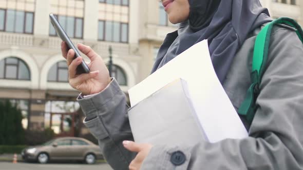 Muslim Girl Using Phone, Waiting for Friends Near College, Education in Europe alt