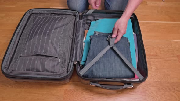 Close up view of man packing clothes in luggage before traveling. Sweden. alt
