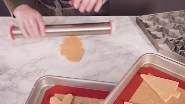 Step by step. Cutting out shapes with Christmas cookies cutter from sugar cookie dough. alt